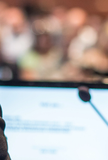 A woman presenting to a full auditorium